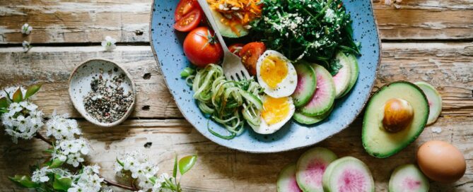 poached egg with vegetables and tomatoes on blue plate