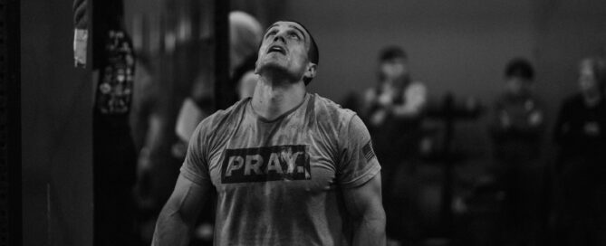 a man standing in a gym holding a barbell