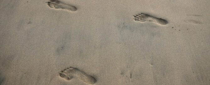 Empreintes de pas dans le sable mouillé d'une plage