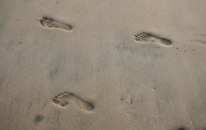 Empreintes de pas dans le sable mouillé d'une plage